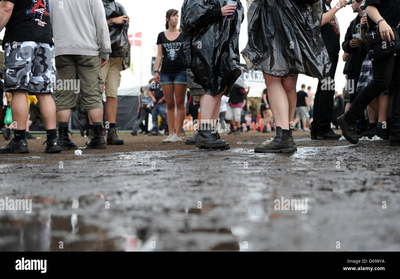 Festival visitors stand in front of a puddle of mud at Wacken Open Air  Festival in Wacken, Germany, 02 August 2012. The world's biggest heavy  metal festival takes place from 02 till