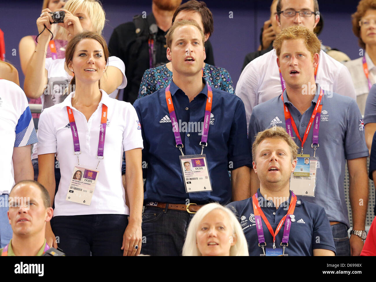 Prince William (C), Duke of Cambridge and Catherine (L), Duchess of Cambridge Prince Harry (R) sing the national anthem after Great Britain wons the men's team sprint in Velodrom at the London 2012 Olympic Games, London, Great Britain, 02 August 2012. Photo: Christian Charisius dpa Stock Photo