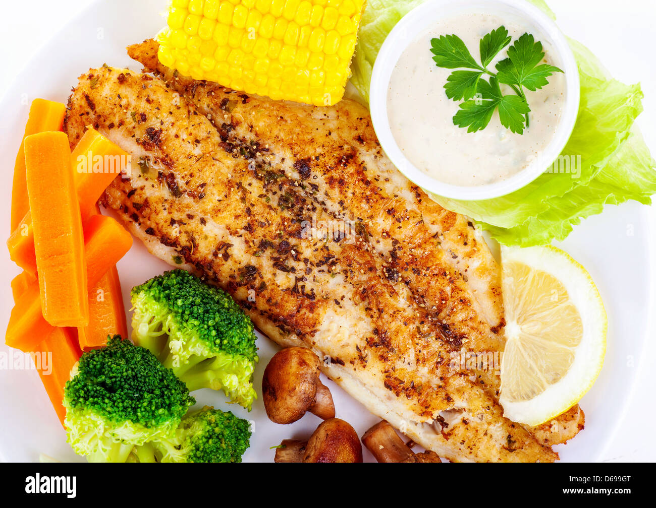 Tasty grilled fish fillet with fresh vegetables and sauce on white plate,  luxury dinner in restaurant, delicious barbecue meat Stock Photo - Alamy