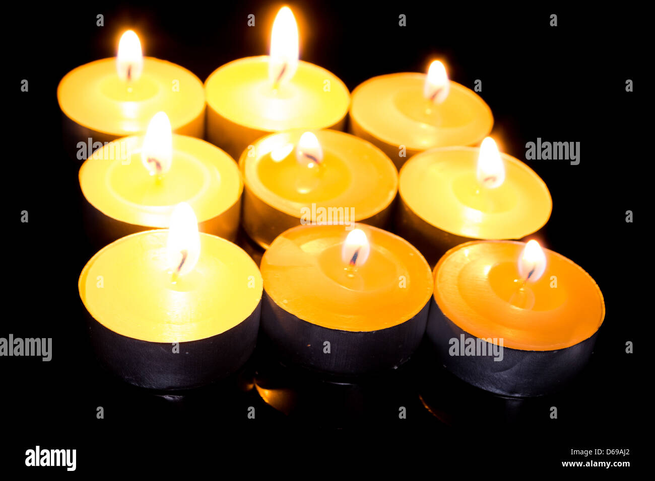 Group of burning candles on black background Stock Photo - Alamy