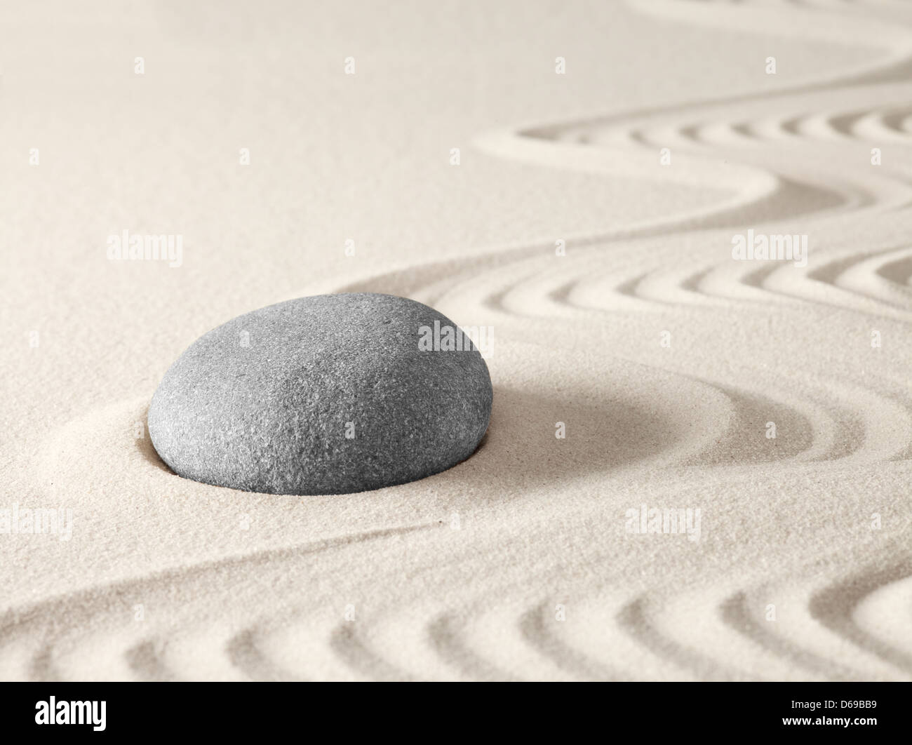 Zen meditation garden with round rock and lines in the sand. yoga buddhism or spa wellness background Stock Photo