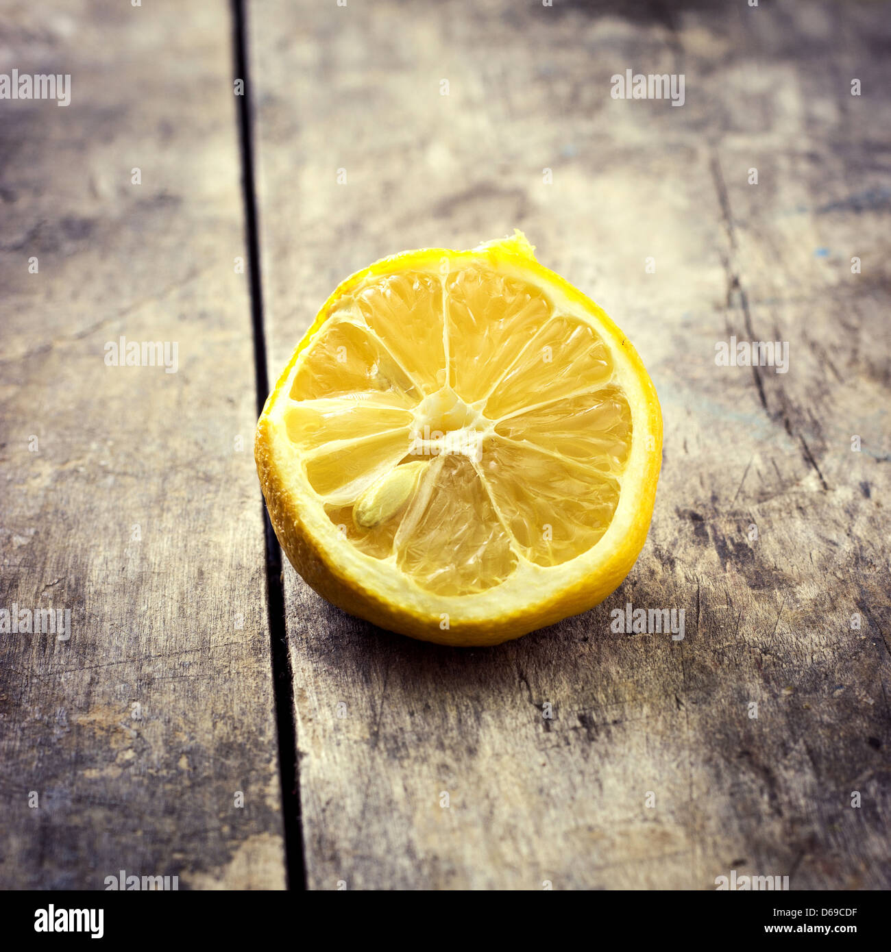 Withered Half Lemon on old wooden table,retro look Stock Photo