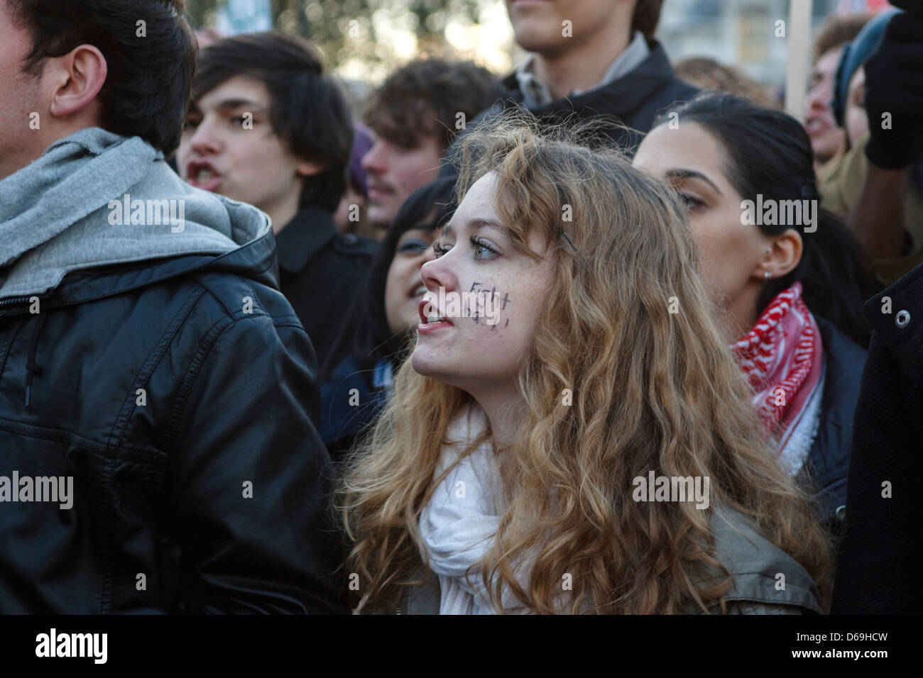 Face Protesting A young woman with a painted face protests outside of the house of ...