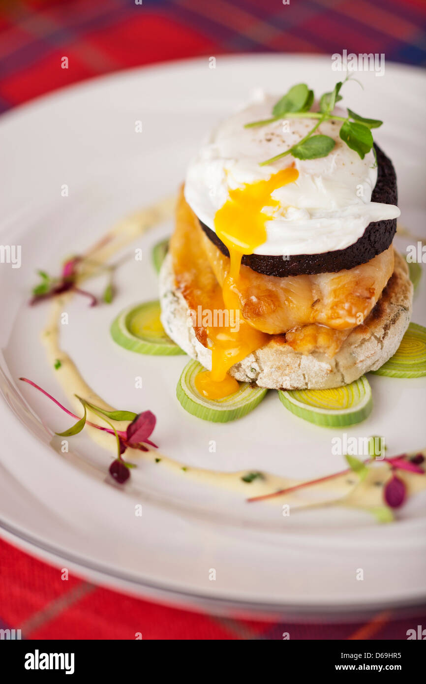 Scottish smoked haddock, Stornoway black pudding and poached egg on potato scone with cream leek souce Stock Photo