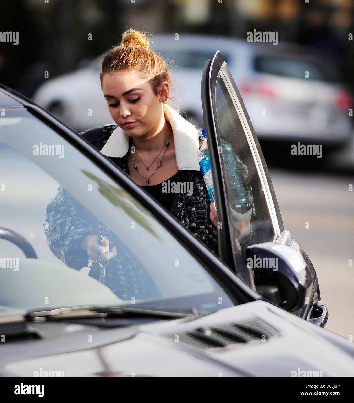 Miley Cyrus carrying a bottle of Fiji Water as she leaves California