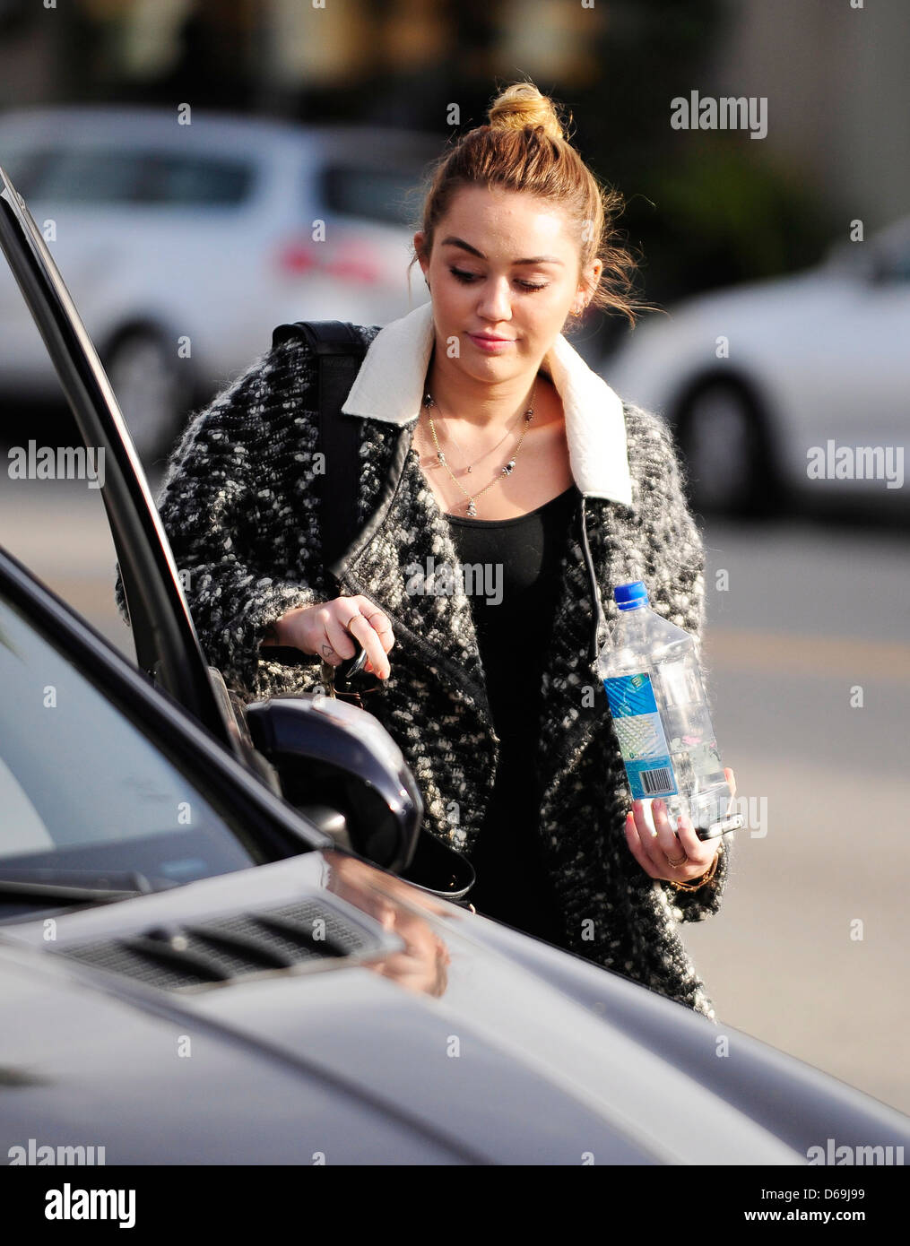 Miley Cyrus carrying a bottle of Fiji Water as she leaves California