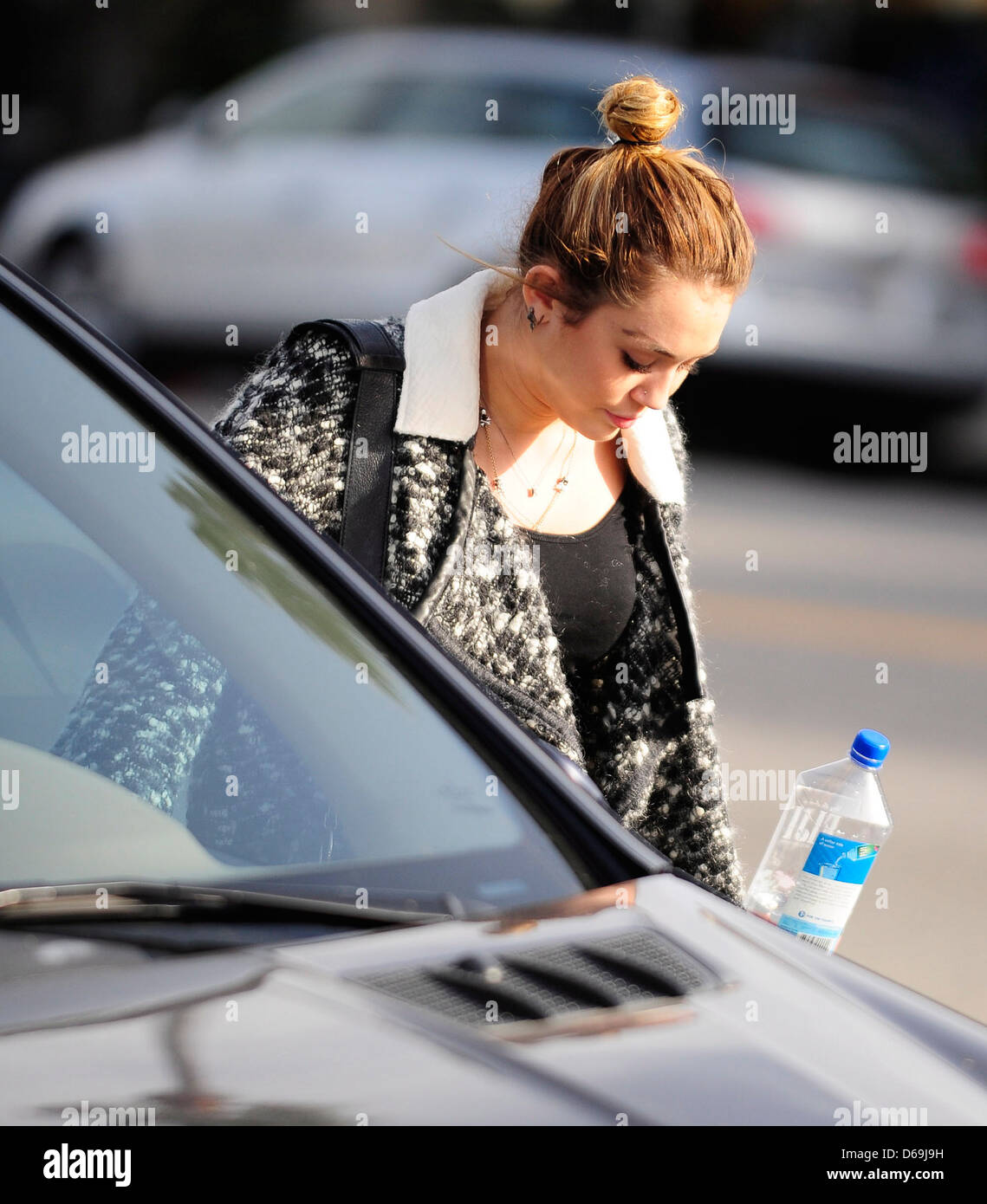 Miley Cyrus carrying a bottle of Fiji Water as she leaves California