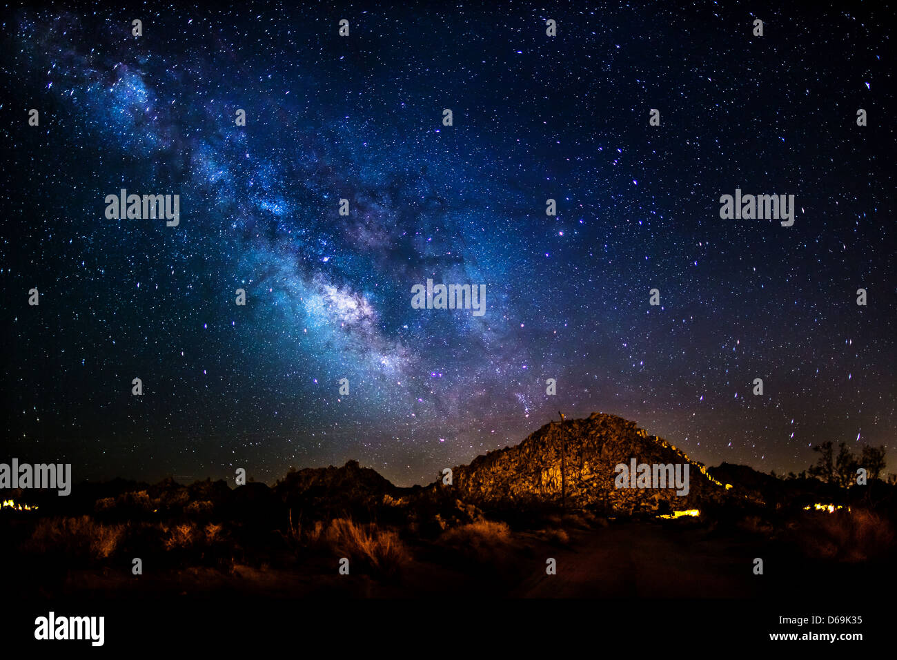 Illuminated night sky over rural landscape Stock Photo