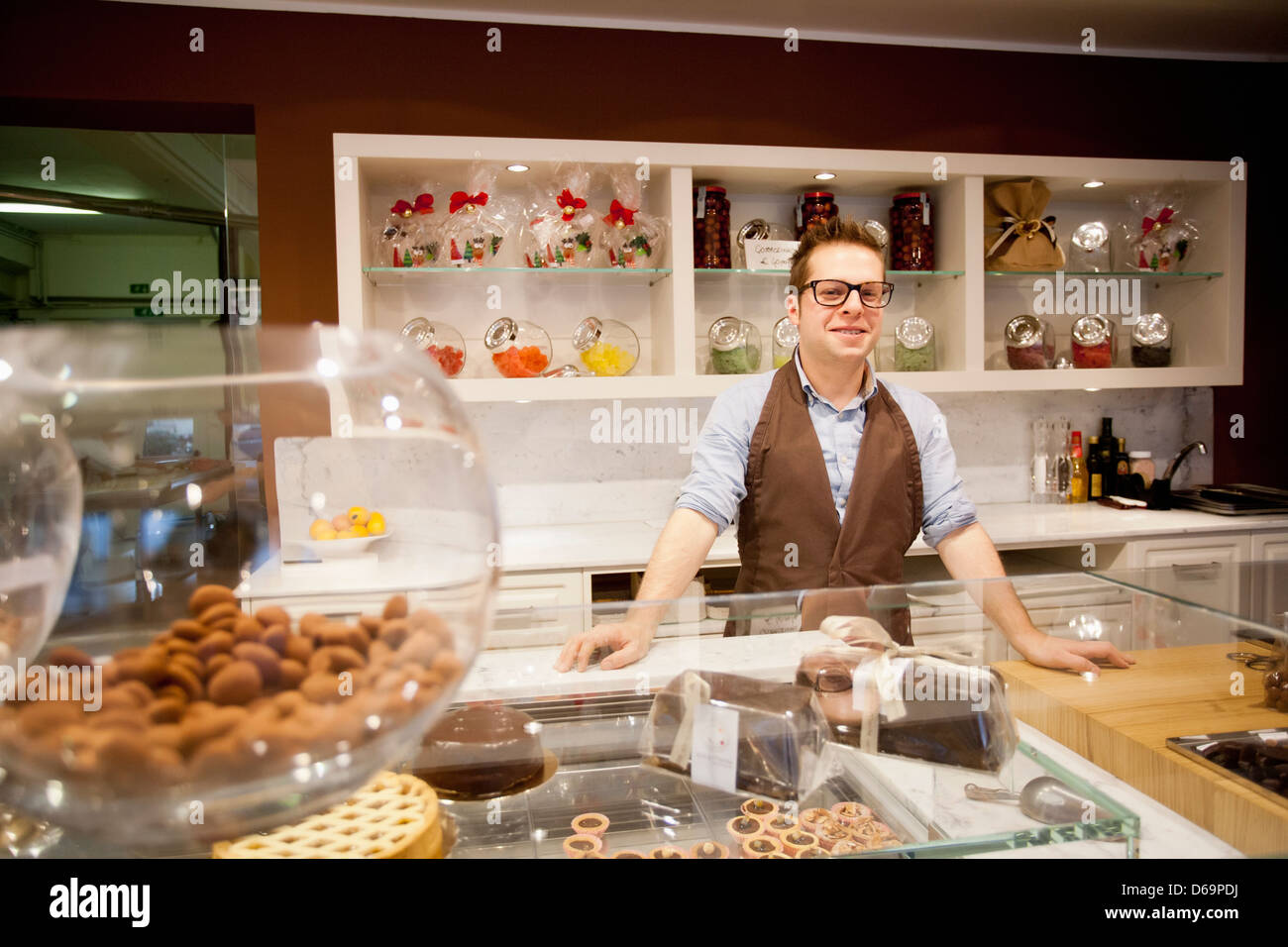 Cashier smiling behind bakery counter Stock Photo