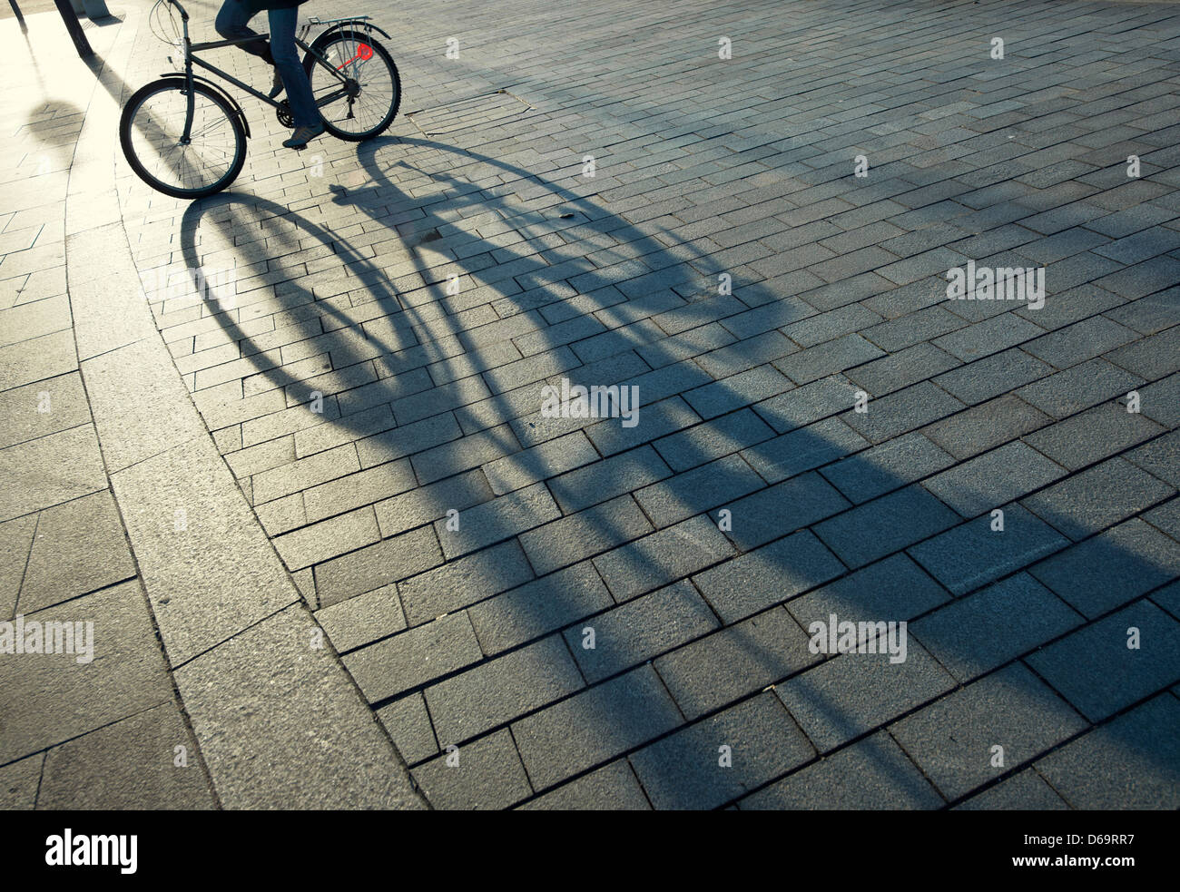 Bicycle casting shadow on city street Stock Photo