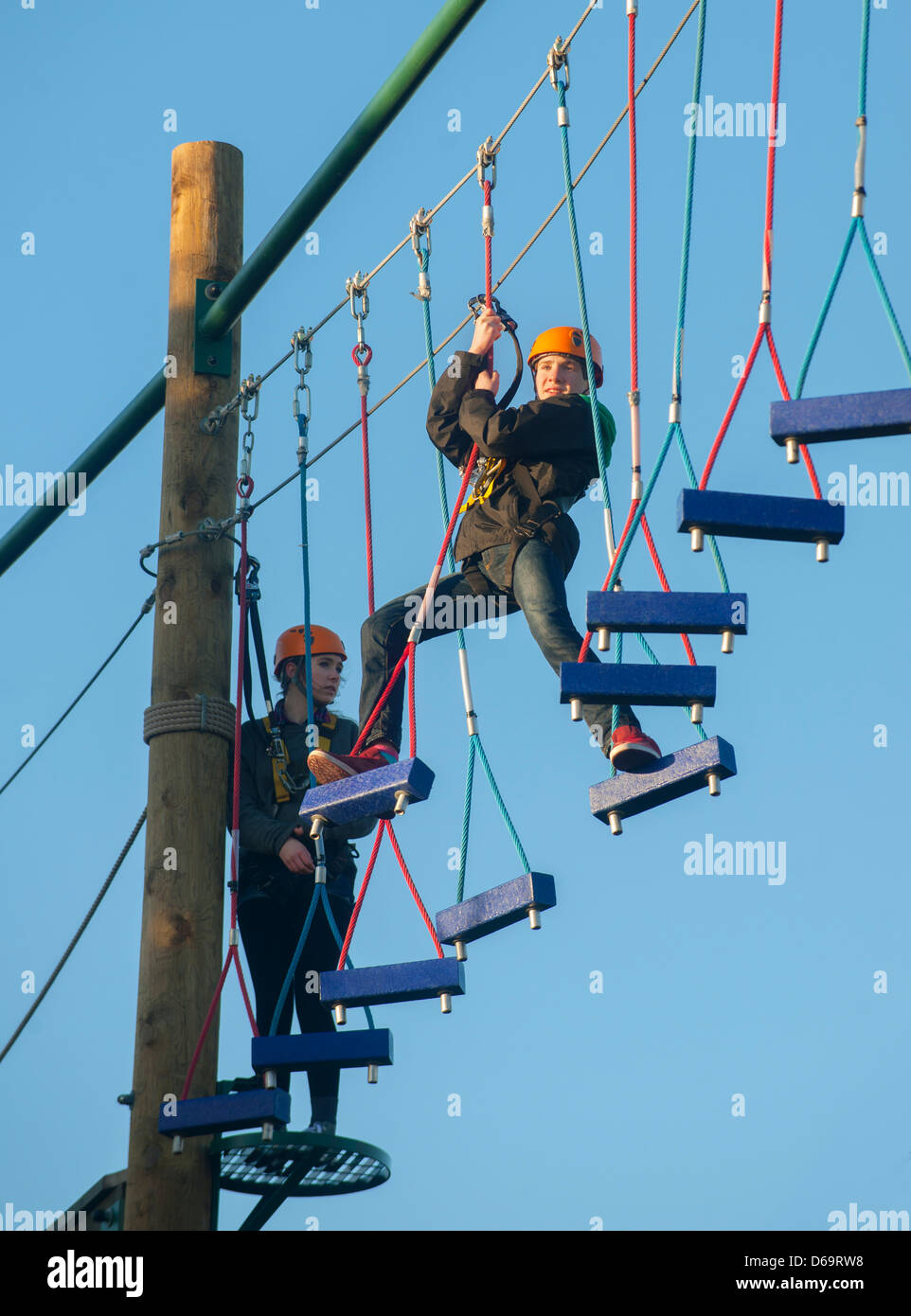 Teenage boys climbing on obstacle course Stock Photo