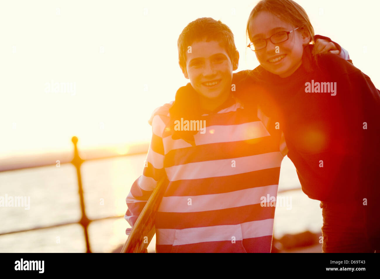 Smiling children hugging outdoors Stock Photo