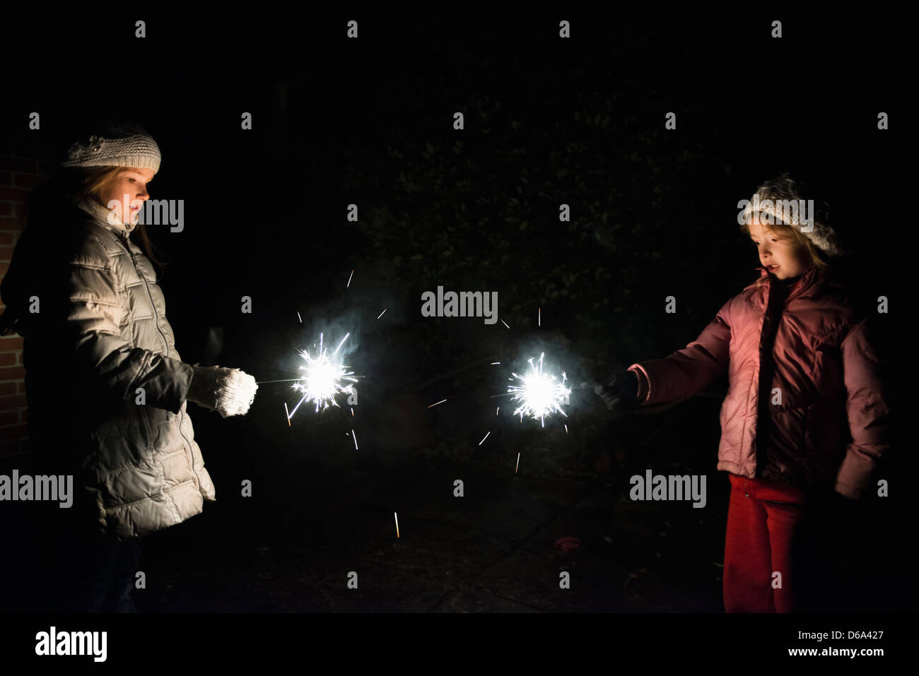 Girls playing with sparklers at night Stock Photo - Alamy