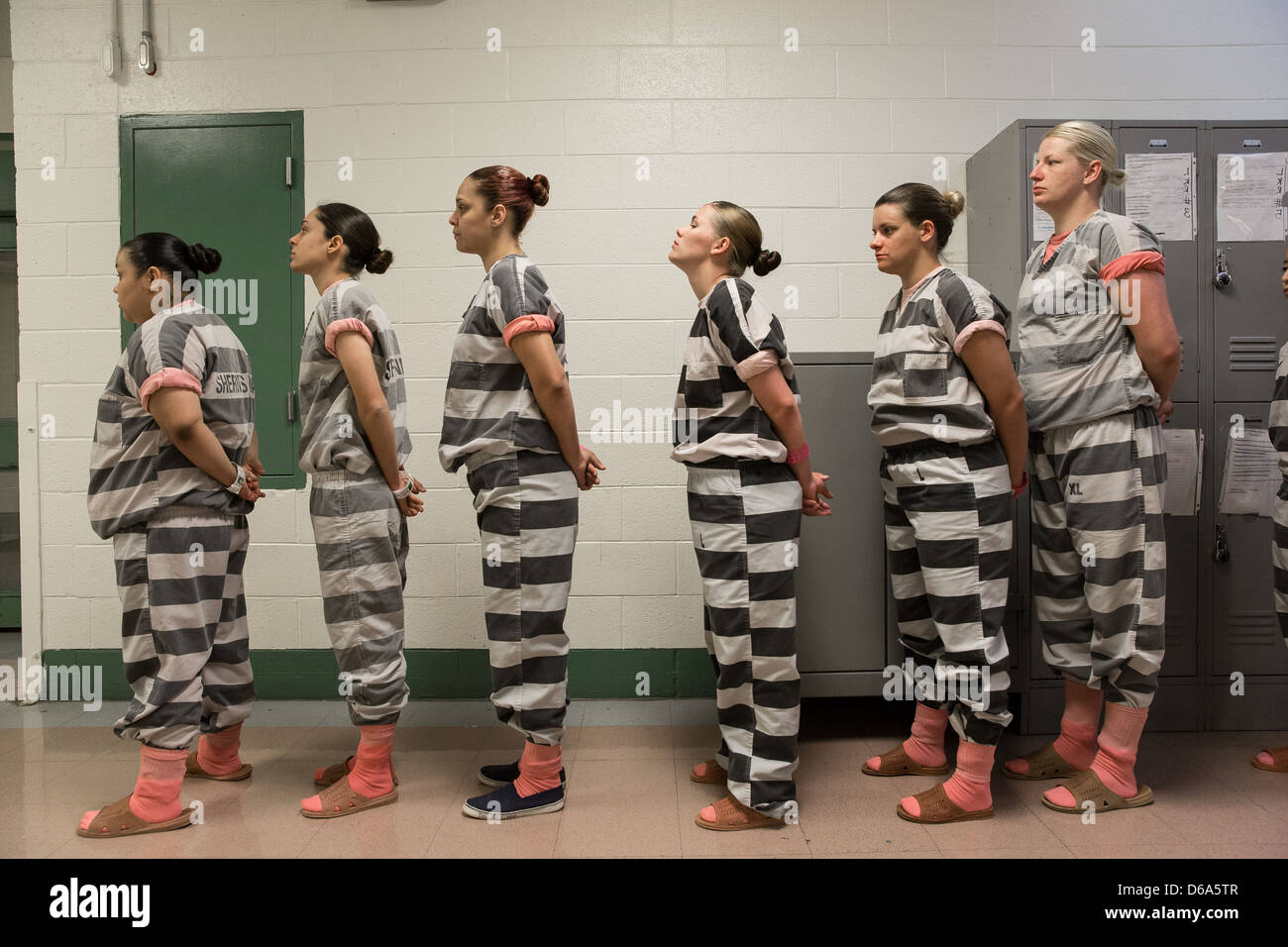 Female inmates wait in line at dawn. Stock Photo