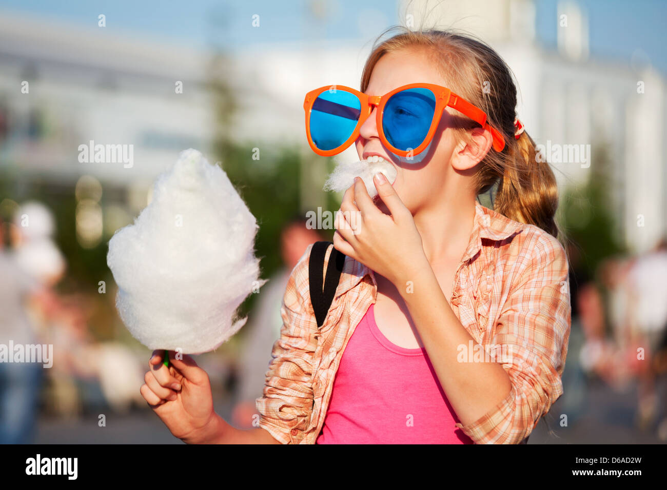 Girl eating cotton candy Stock Photo - Alamy