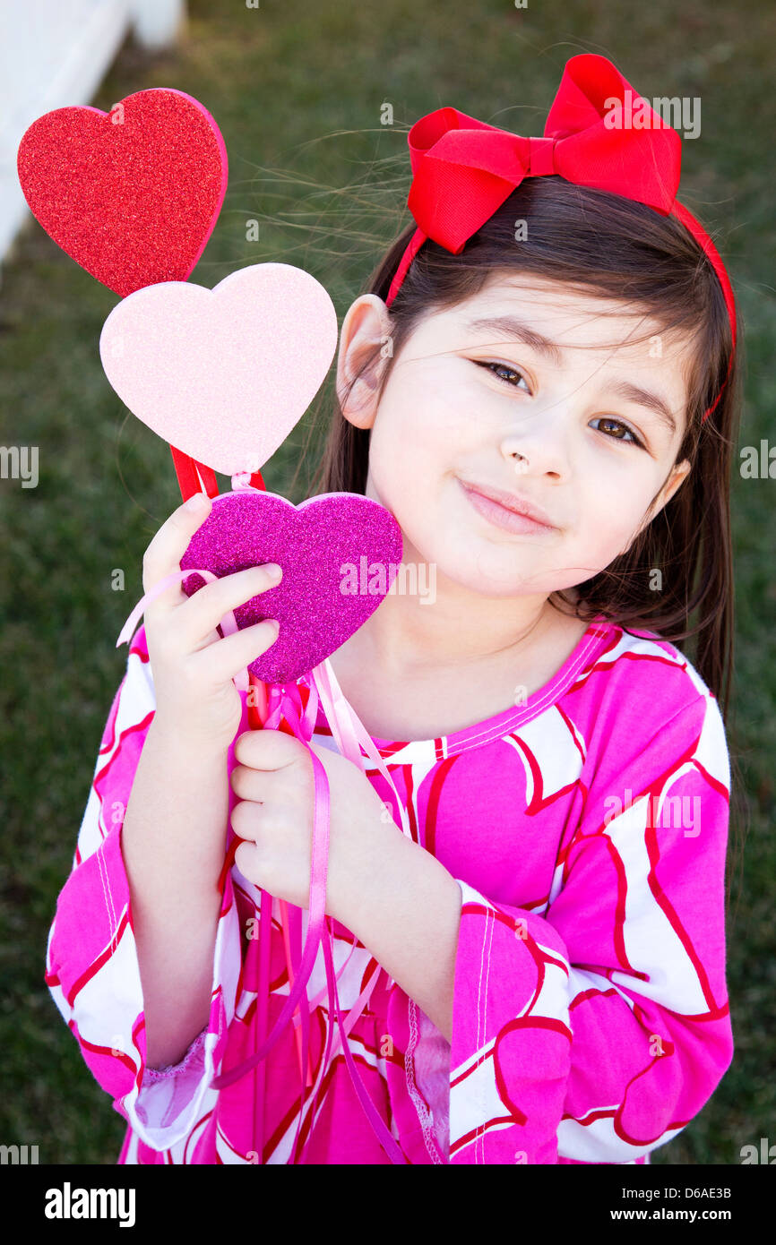 Young Girl Holding Heart Wands Stock Photo