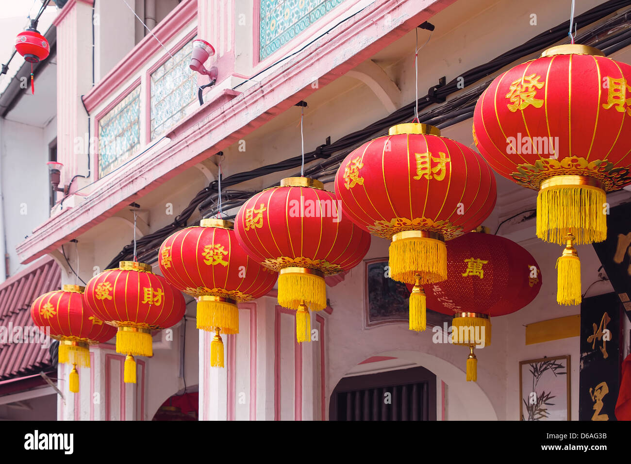 Chinese New Year Red Lanterns with Chinese Text Wishing Good Fortune Hanging on Historic Peranakan Buildings Exterior Stock Photo
