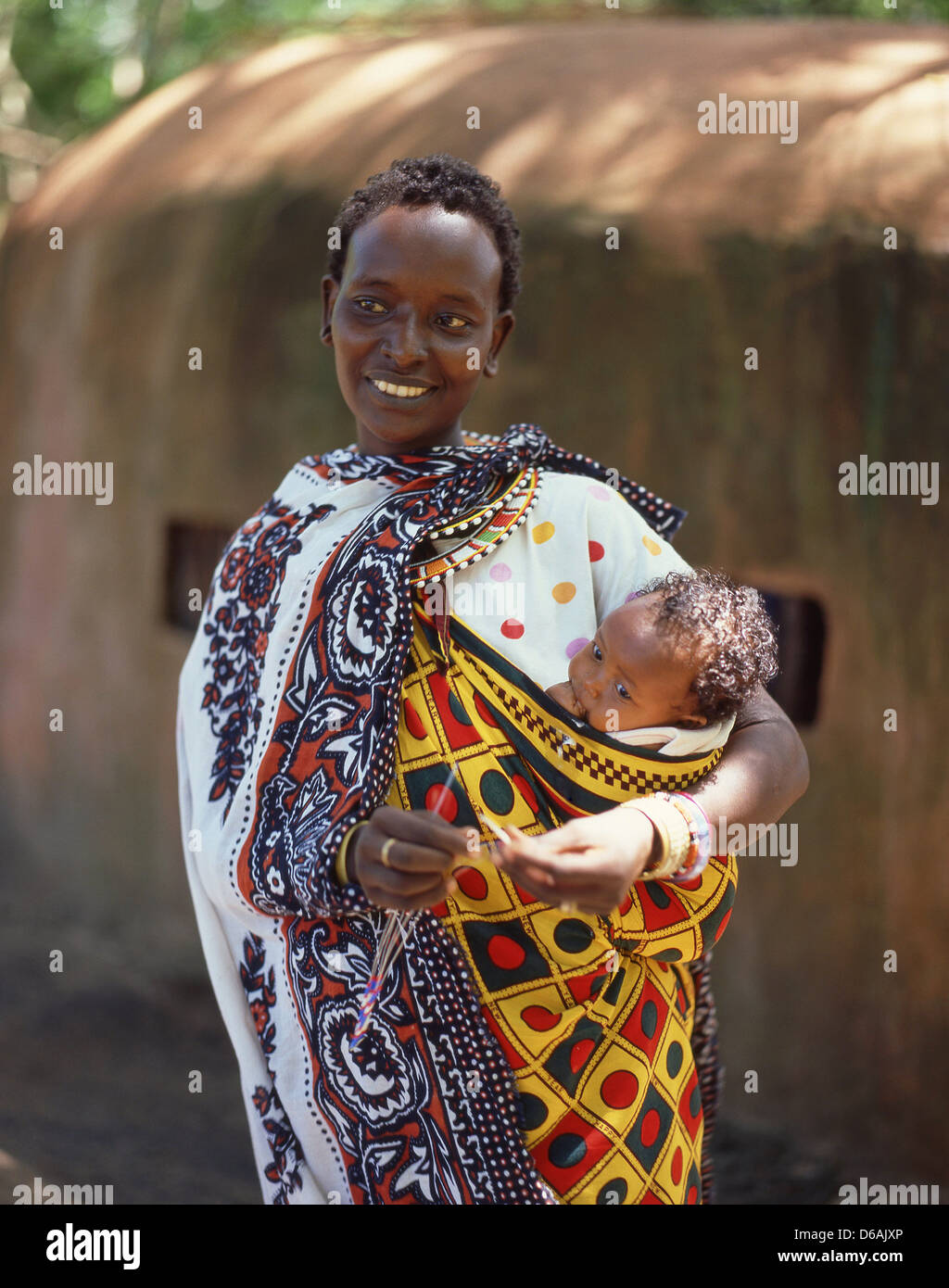 Maasai woman holding baby, Maasai Mara National Reserve, Narok County, Republic of Kenya Stock Photo