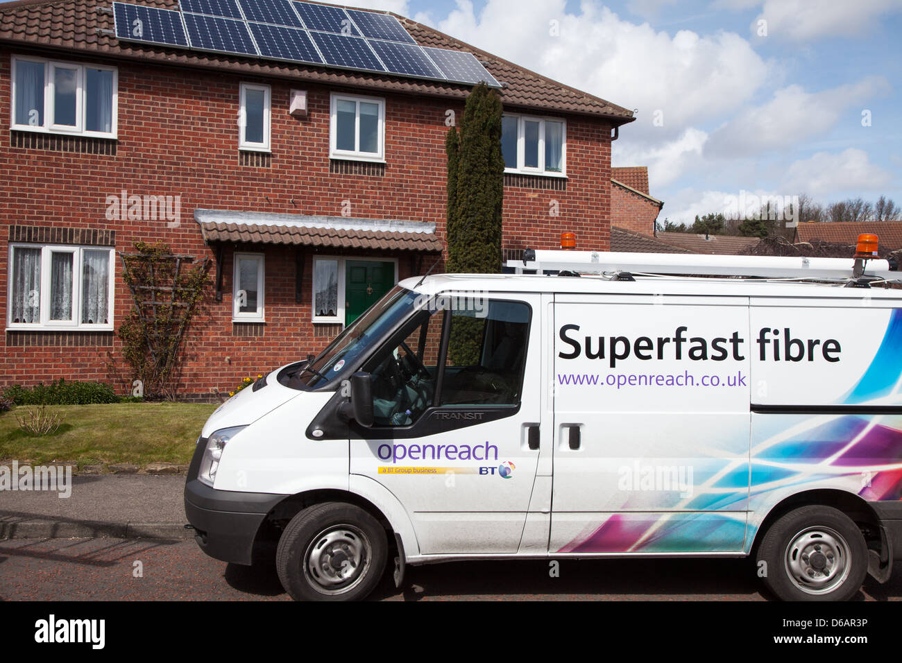 BT Openreach van parked outside detached house while technician installs fibre optic broadband connection. Stock Photo