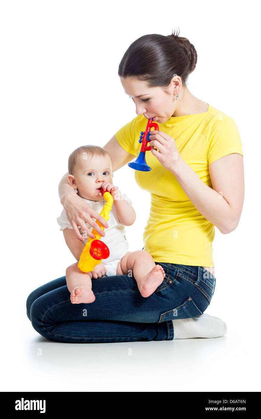 Mother and baby girl having fun with musical toys. Isolated on white background Stock Photo