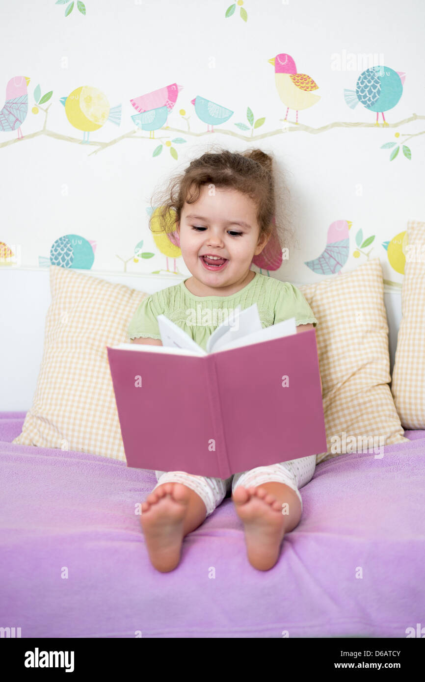 cute happy little girl reading a book Stock Photo - Alamy