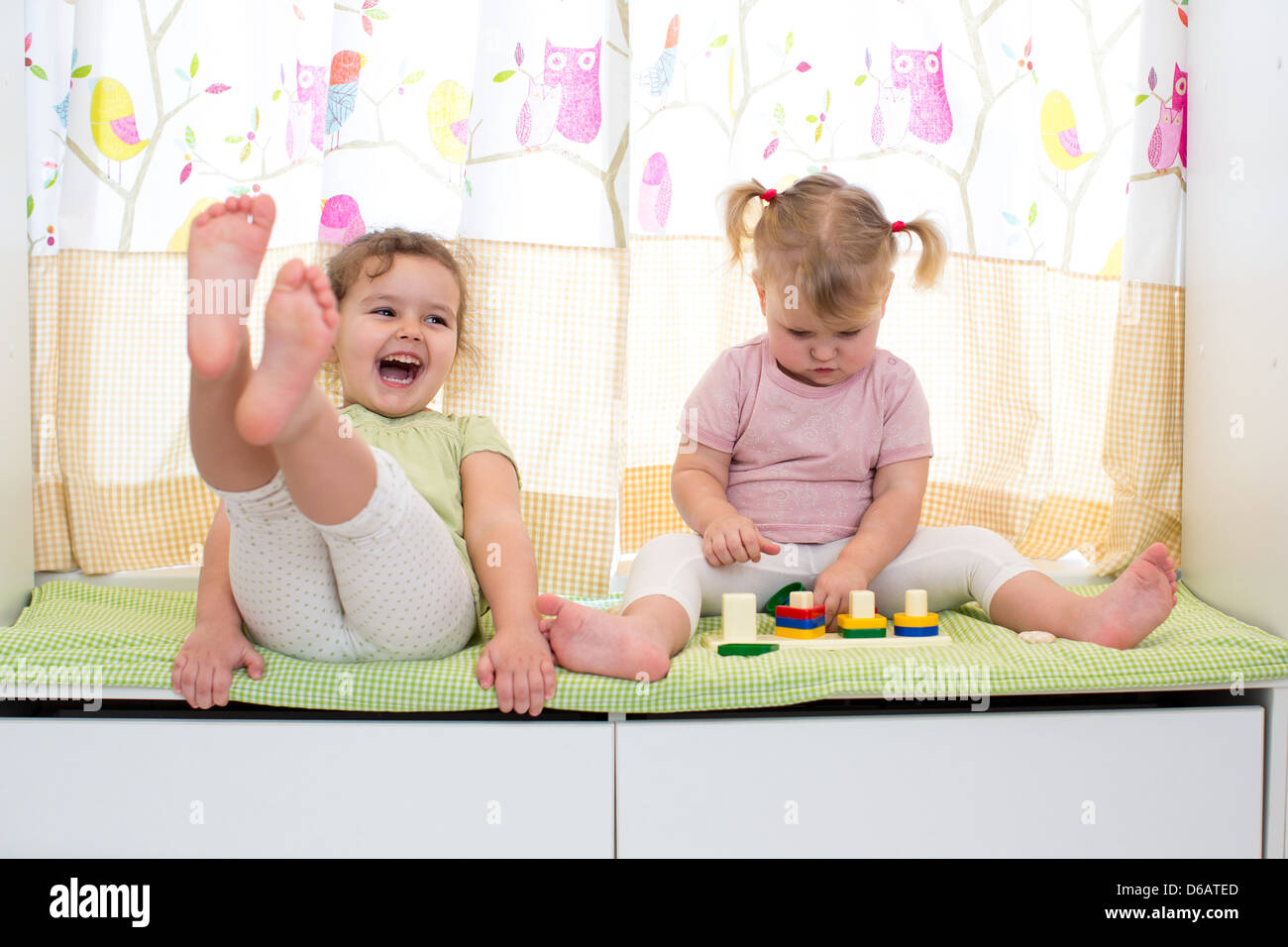 children sisters play together indoors Stock Photo