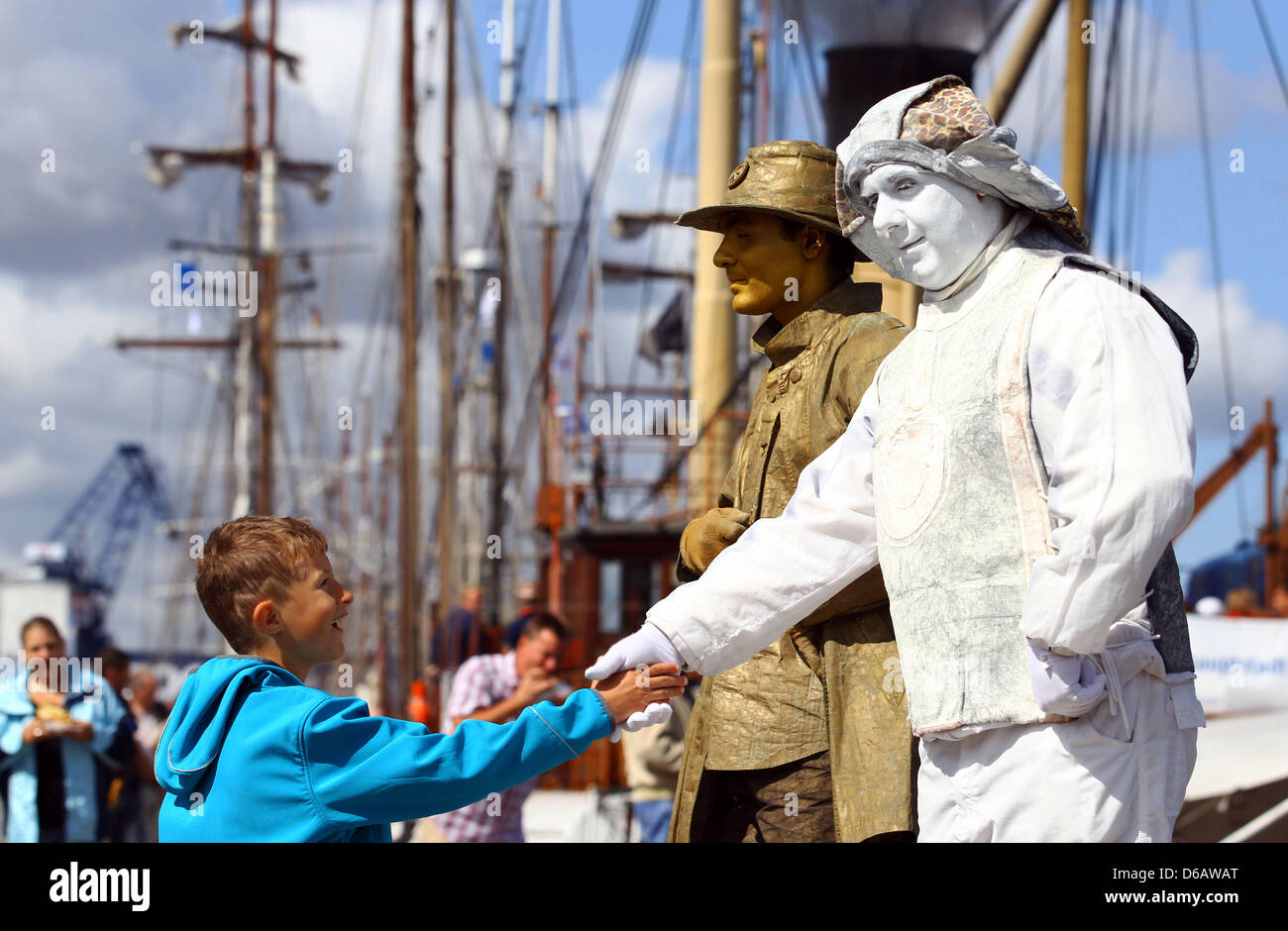 Artists welcome visitors of the 22nd Hanse Sail festival in the harbour in Rostock, Germany, 09 August 2012. The maritime festival runs from 09 until 12 August 2012 and features 170 traditional and museum ships. Photo: Jens Buettner Stock Photo
