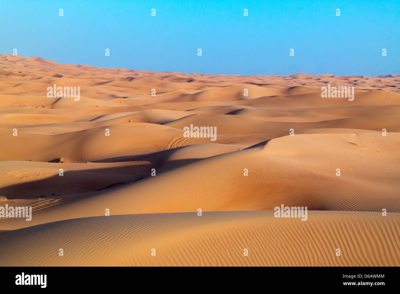 Arabian desert dune background on blue sky. Desert near the city of Dubai.  desert landscape. dunes stretching into skyline Stock Photo - Alamy