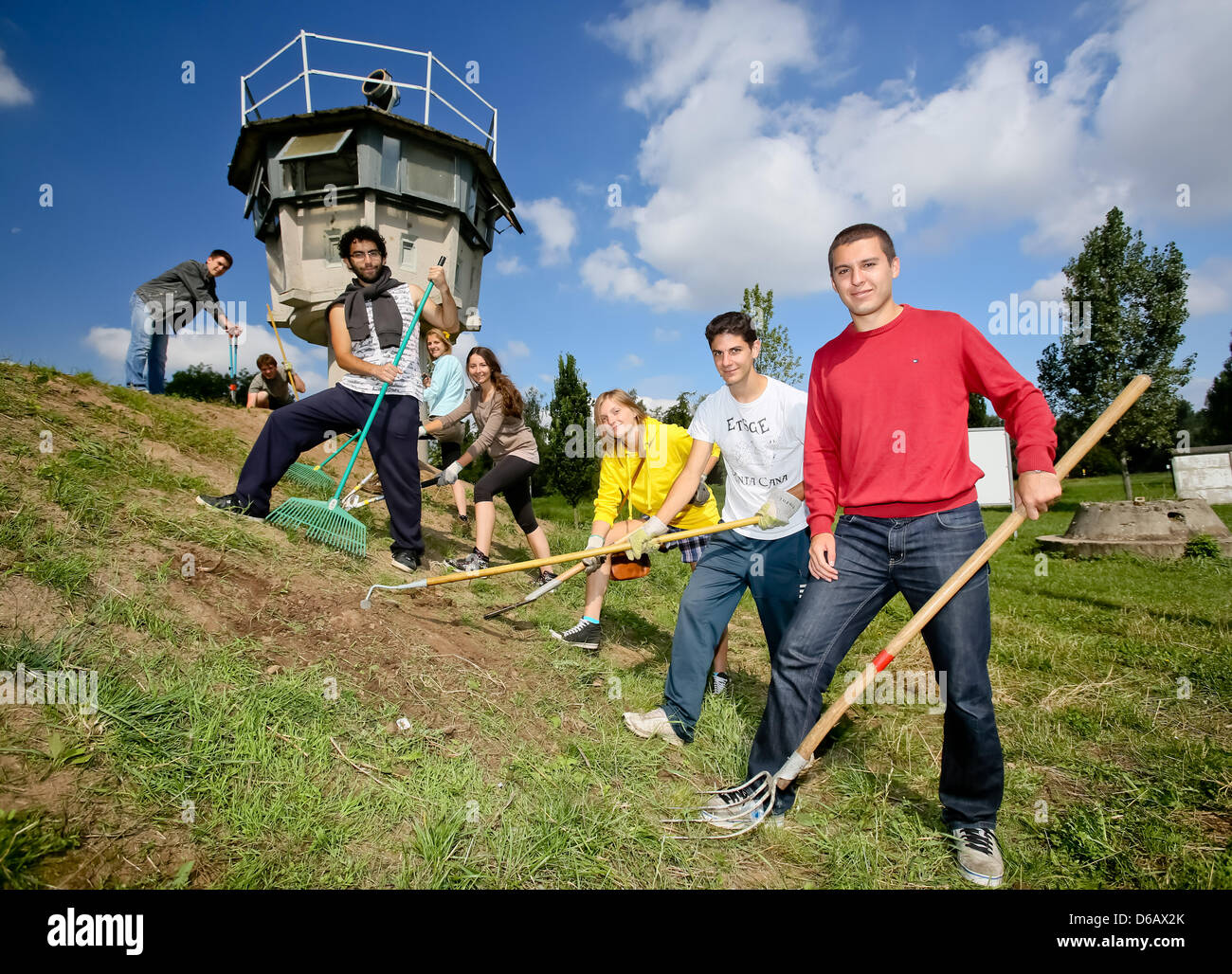 Participants of an international youth work shop garden the area of former GDR border installations near Hoetensleben, Germany, 08 August 2012. The memorial site Hoetensleben fights against being forgotten. Therefore, juveniles from across the world help maintain the site every year. Photo: ANDREAS LANDER Stock Photo