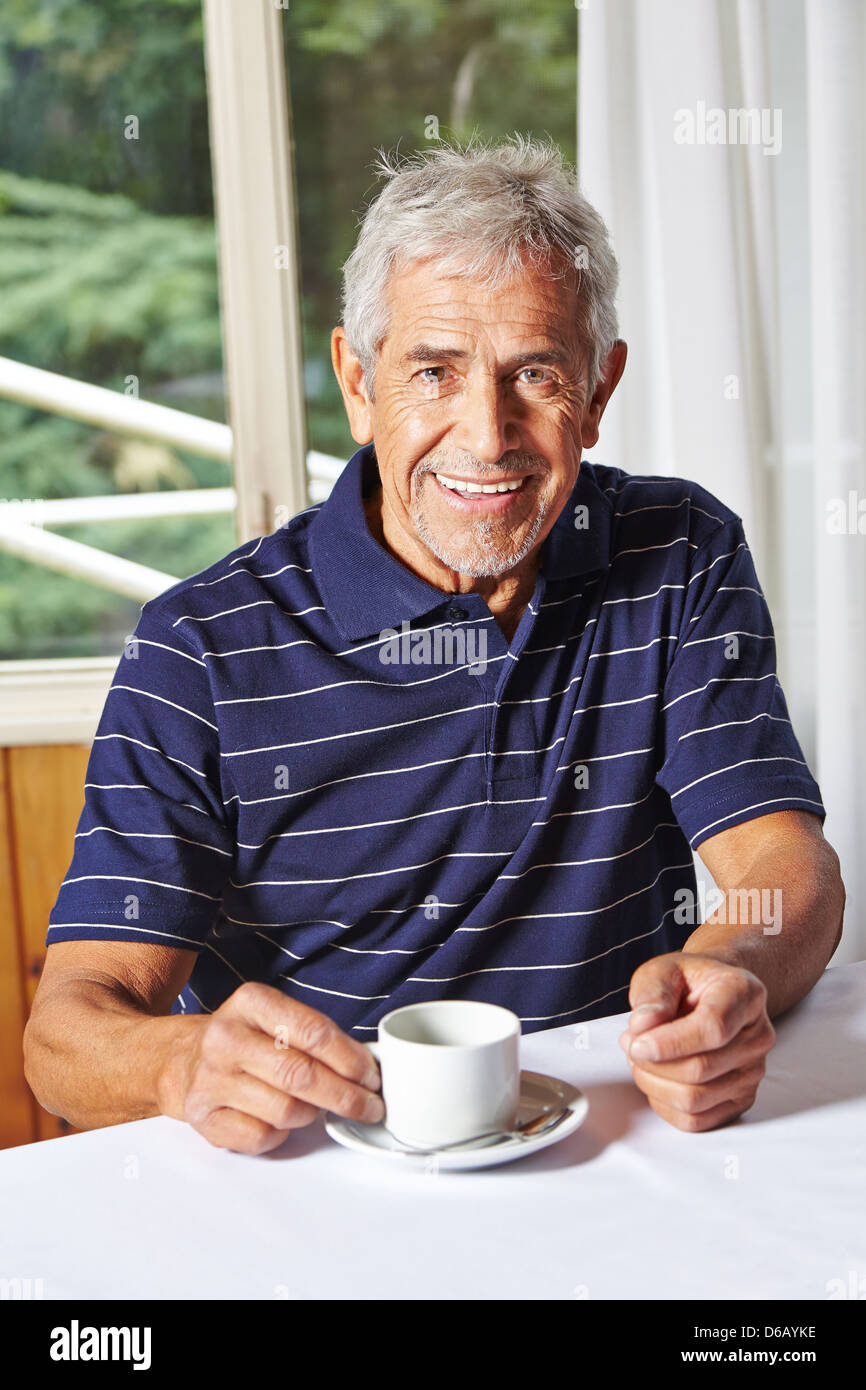 Happy senior man drinking a cup of coffee in a nursing home Stock Photo