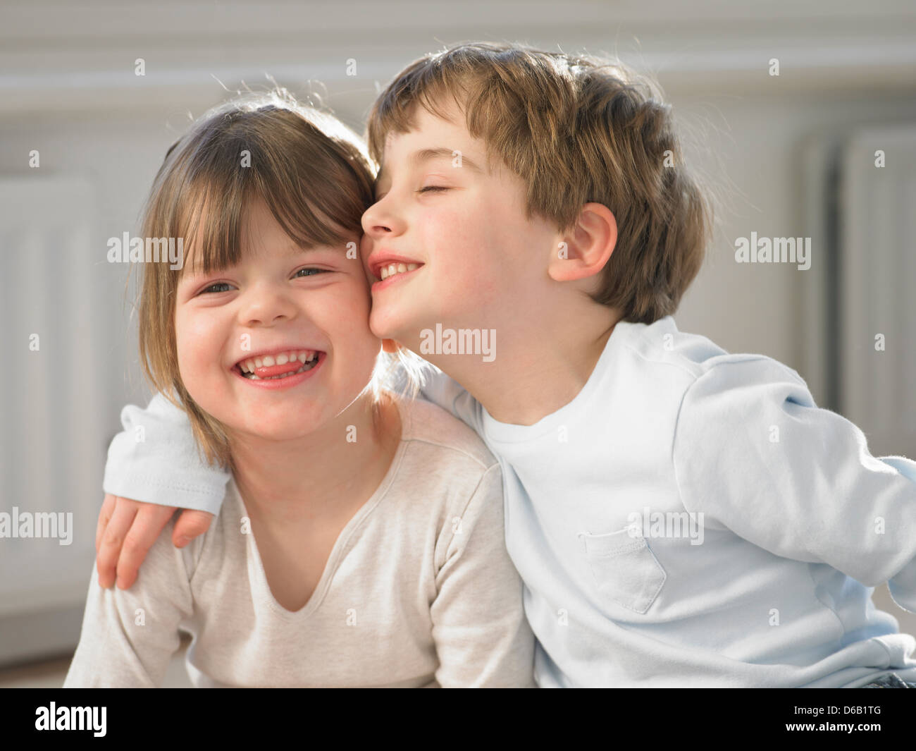 Smiling children hugging indoors Stock Photo