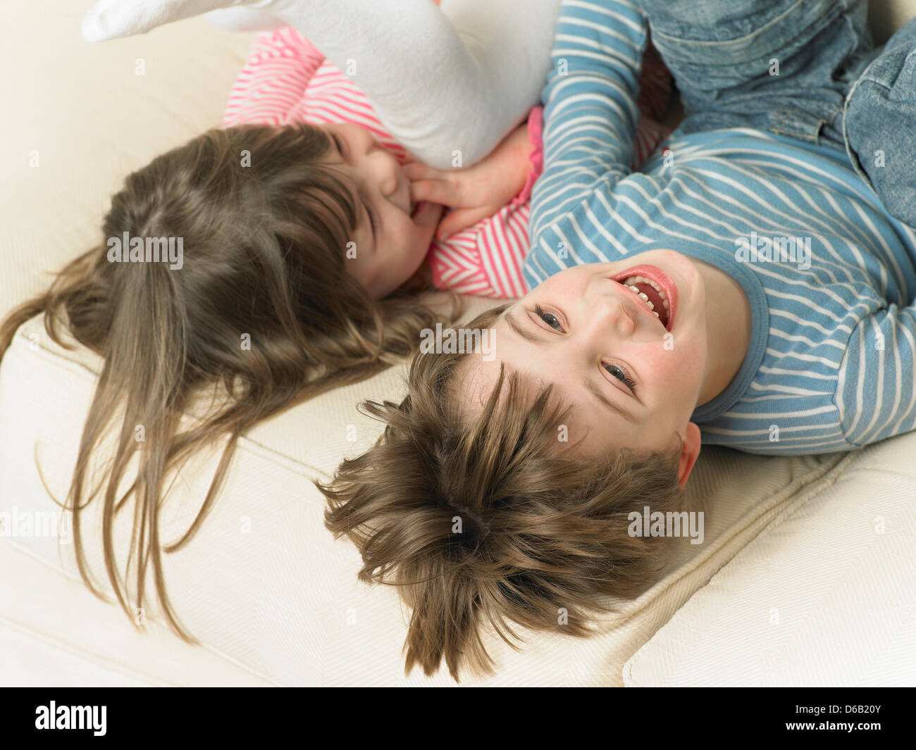 Children playing on sofa together Stock Photo
