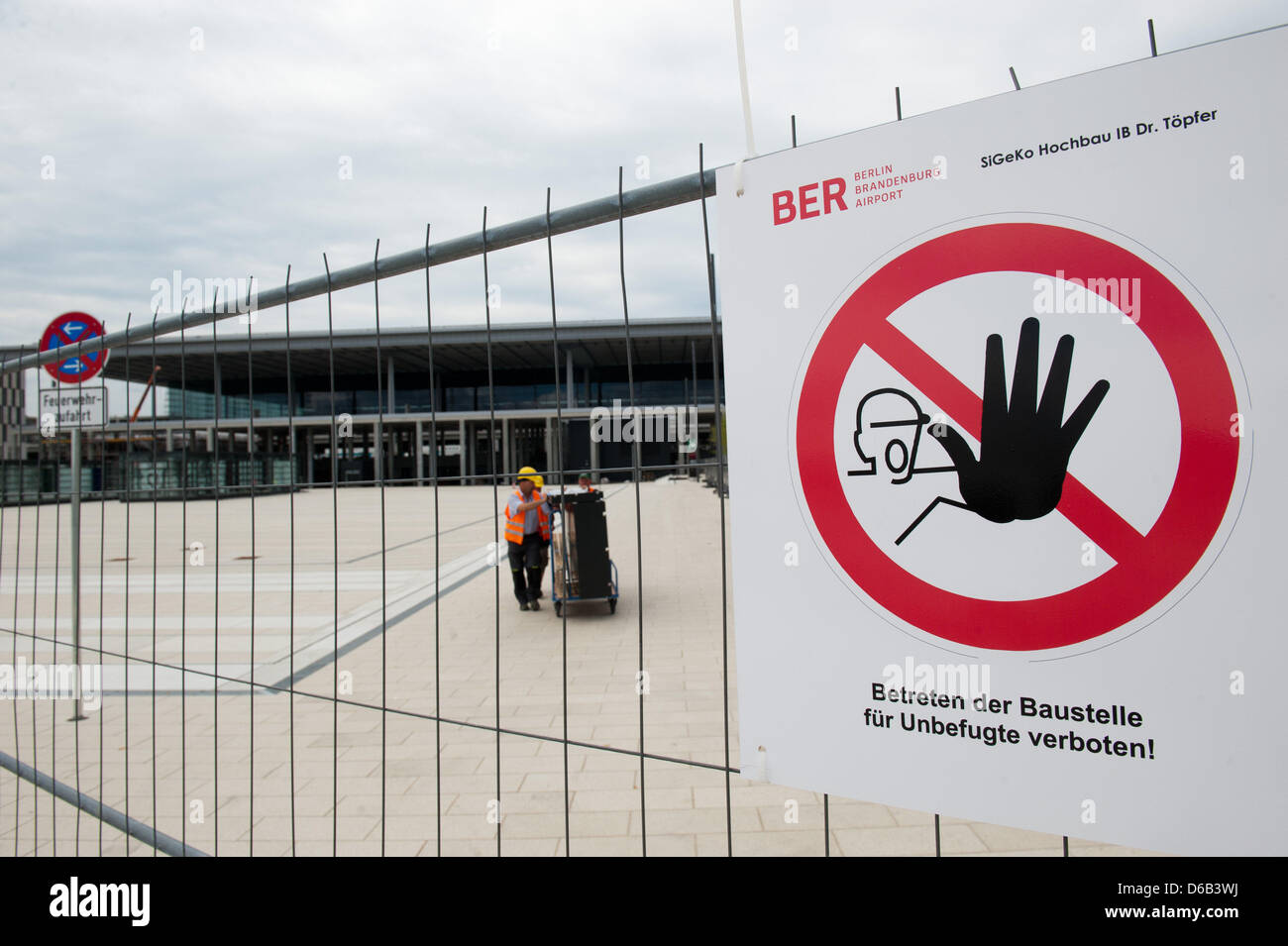 A sign warns of entering the construction site at the Berlin Brandenburg Airport (BER) in Schoenefeld, Germany, 16 August 2012. The supervisory board of the airport company tries to find anwers for the as yet unsolved problems of the unfinished airport project. The main focus might be the question of how to deal with the additonal costs of 1.177 billion euros and if the opening dat Stock Photo