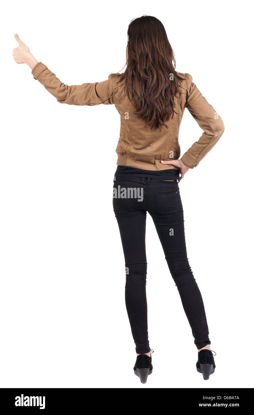 Back view of of beautiful brunette woman in brown jacket makes thumb up. Showing of positive emotions with OK sign concept. Stock Photo