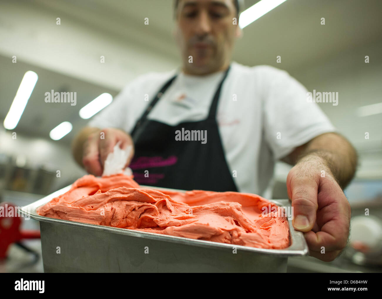 An employee of the ice-cream manufacturer Aperto from the Fontanella company a container with strawberry ice-cream in Mannheim, Germany, 17 August 2012. The family company has made ice-cream for almost 90 years. Photo: Uwe Anspach Stock Photo