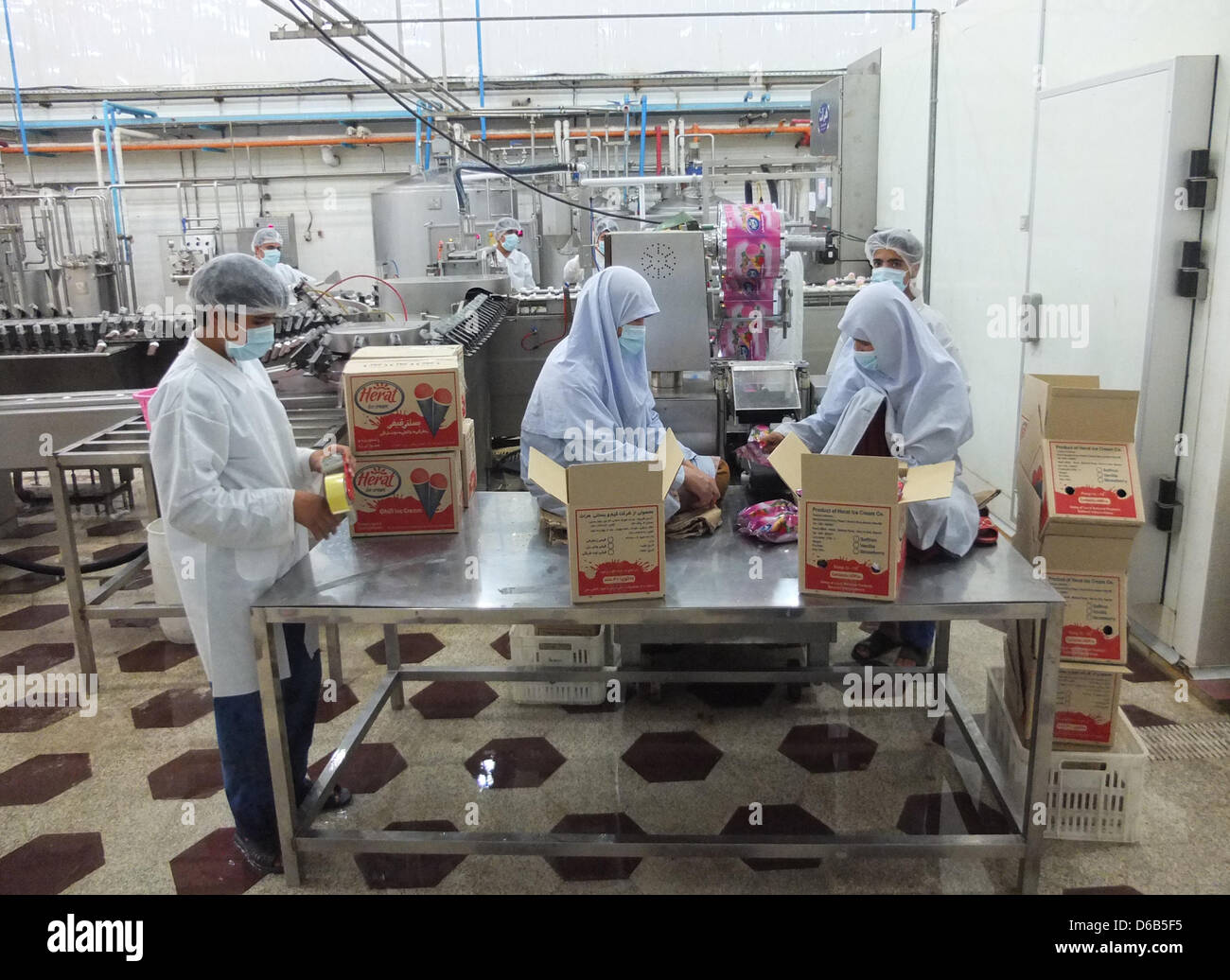 Employees of an icecream factory package ice cream for shipping in