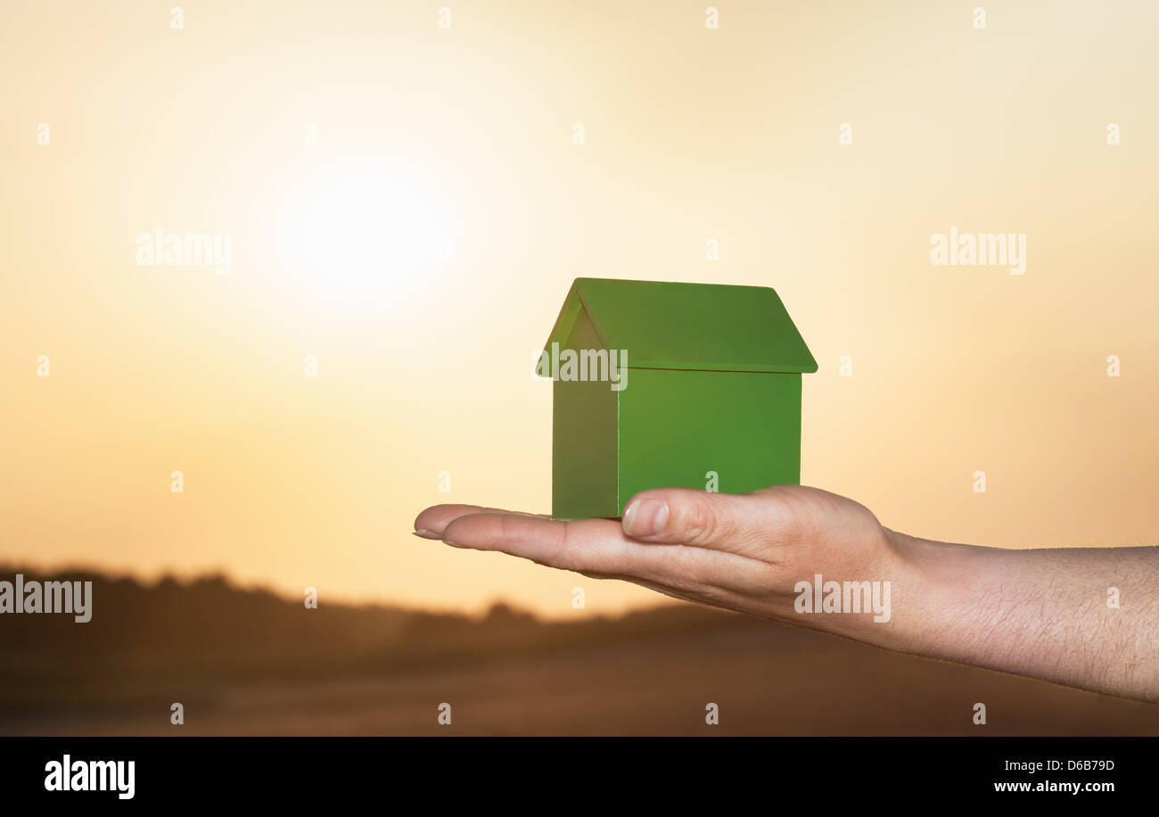Hand holding model house outdoors Stock Photo - Alamy