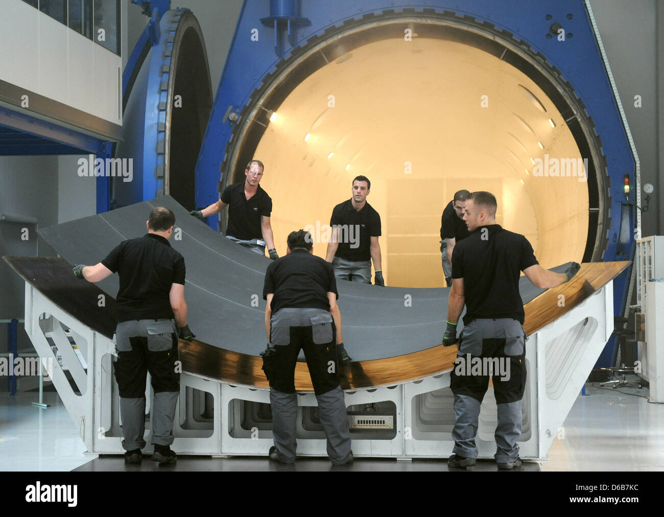 DLR employees take the finished hardened CFK parts from the world's