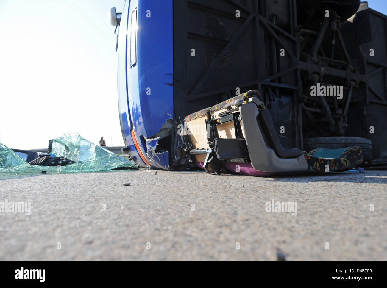 A sheet of glass and two seats sit next to a tour bus on its side on Autobahn A92 between the Neufahrn interchange and the exit Freising Sued near Freising, Germany, 22 August 2012. More than 35 people were injured in the accident, including 30 children, according to the police. The bus lost control in the sudden heavy rain and hail, according to eye witnesses. Photo: ANDREAS GEBER Stock Photo