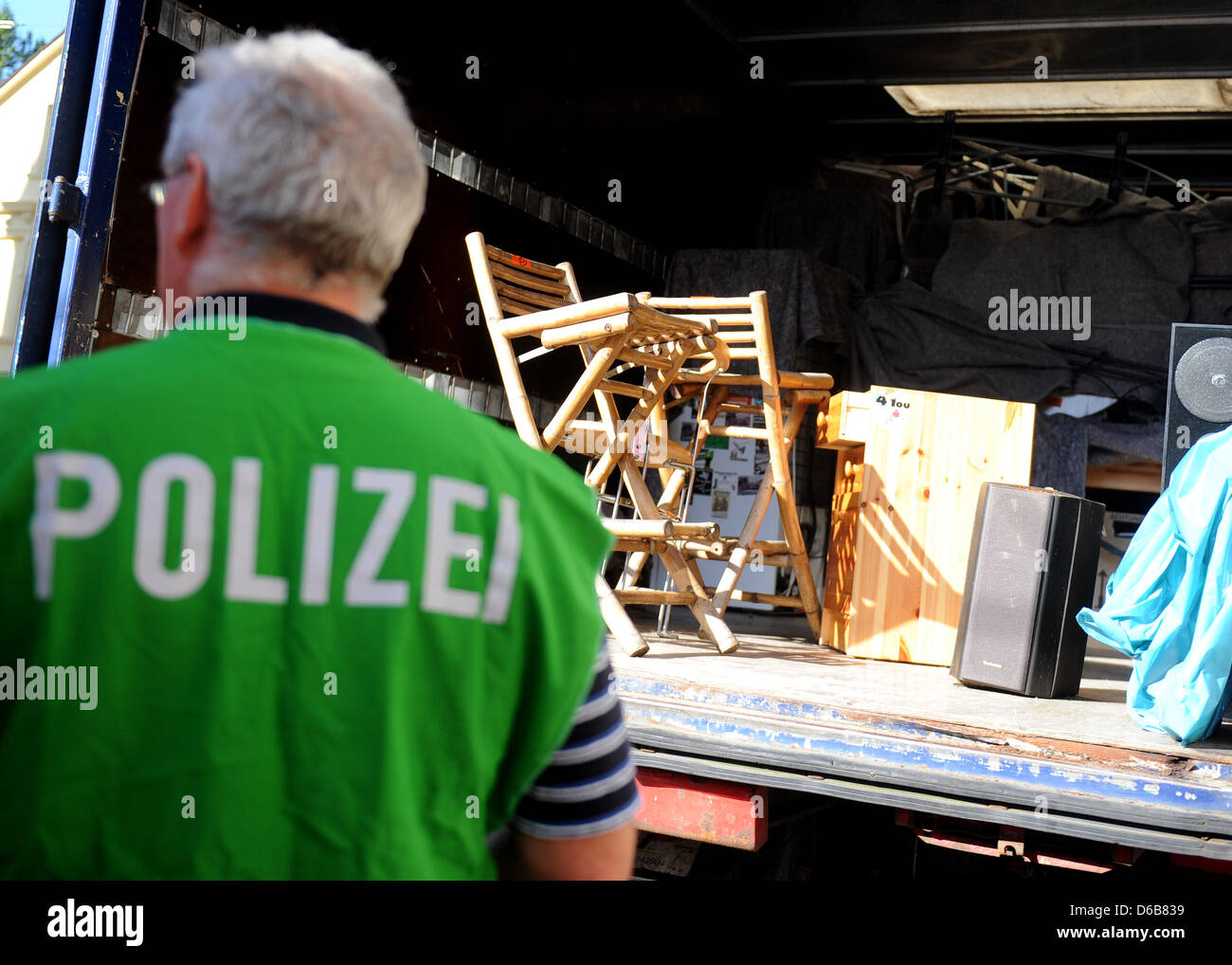 A police officer guards a lorry filled with objects that were seized during a house search in Dortmund, Germany, 23 August 2012. Police were out in force after the North Rhine-Westphalian Interior Minister outlawed three right-wing extremist organizations, the 'Kameradschaft Aachener Land', the 'Nationaler Widerstand Dortmund' and the 'Kameradschaft Hamm'. Photo: CAROLINE SEIDEL Stock Photo
