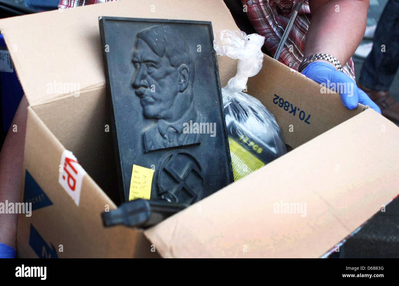 Policemen seize a Adolf Hitler relief during a house search of right-wing extremist organization 'Kameradschaft Aachener Land' in Juelich, Germany, 23 August 2012. Police were out in force after the North Rhine-Westphalian Interior Minister outlawed three right-wing extremist organizations, the 'Kameradschaft Aachener Land', the 'Nationaler Widerstand Dortmund' and the 'Kameradscha Stock Photo