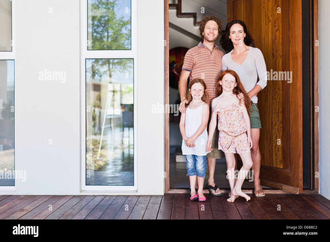 Family smiling at front door Stock Photo - Alamy