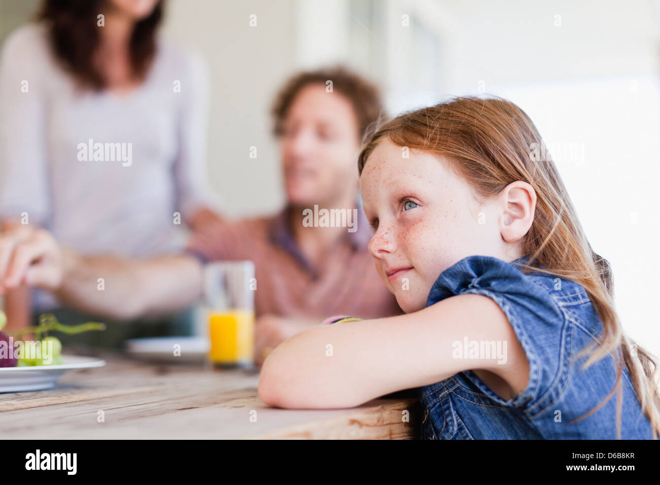 Girl sitting at breakfast table Stock Photo