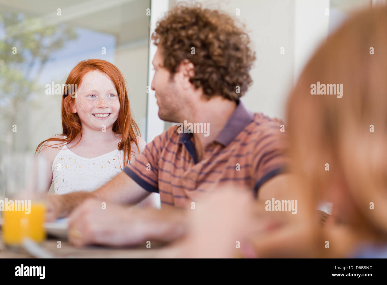 Girl smiling at father at breakfast Stock Photo