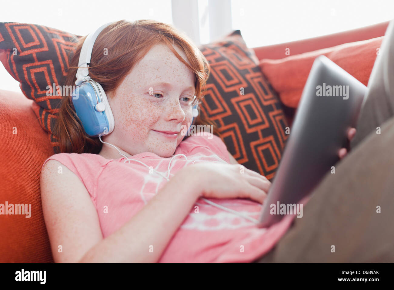 Girl in headphones using tablet computer Stock Photo