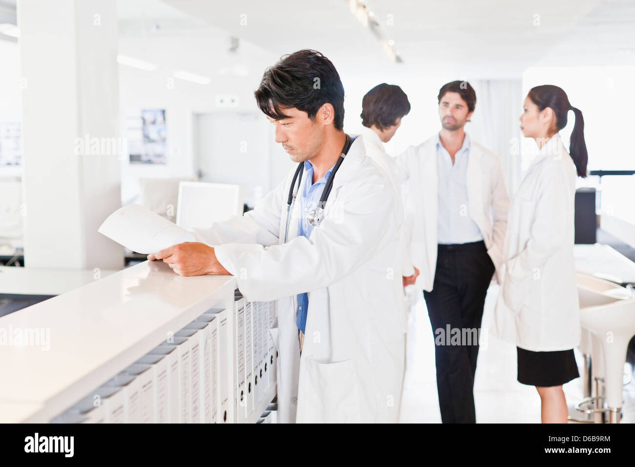 Doctor reading his notes in hallway Stock Photo
