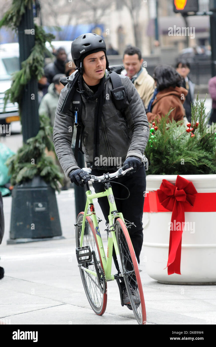 Zac Efron dressed as a bike messenger on the set of his new film 'New Year's Eve' shooting in Manhattan New York City, USA - Stock Photo