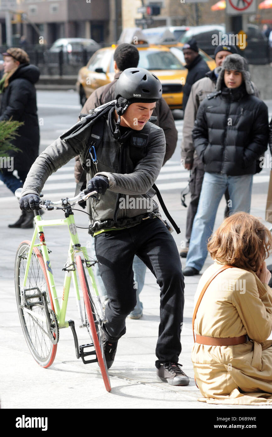 Zac Efron dressed as a bike messenger on the set of his new film 'New Year's Eve' shooting in Manhattan New York City, USA - Stock Photo
