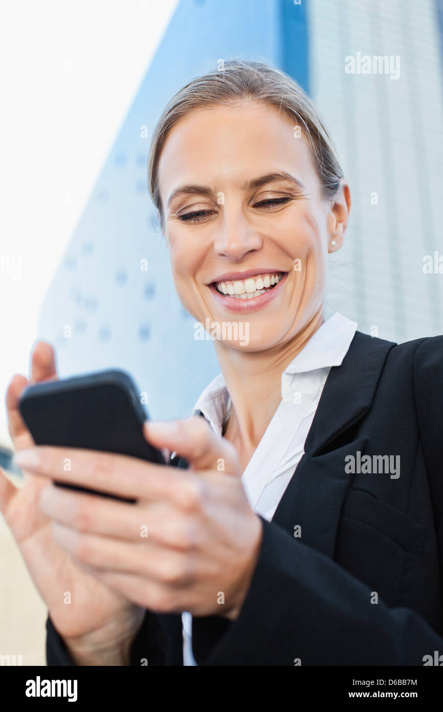Businesswoman using cell phone outdoors Stock Photo