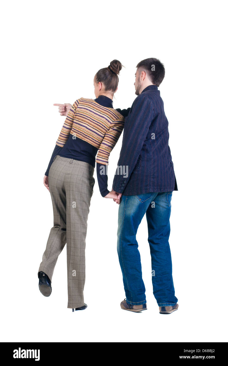 Young couple pointing at wall. Rear view. Isolated over white background. Stock Photo